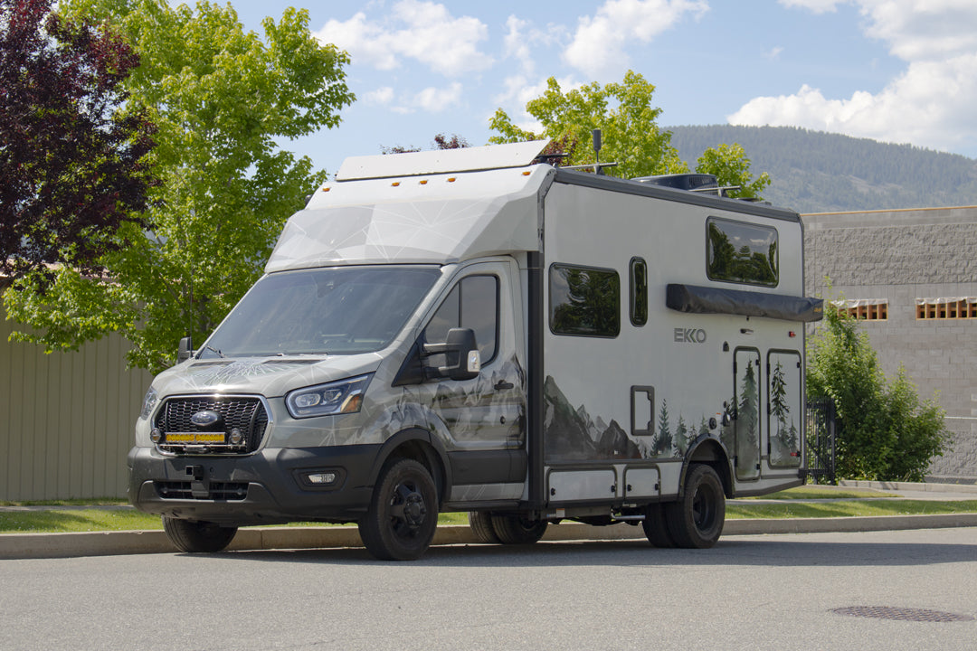 A camper van parked in a lot, showcasing OPTI-RATE REPLACEMENT LEAF SPRINGS for TRANSIT (PAIR), emphasizing its enhanced ride height and spring rate flexibility.