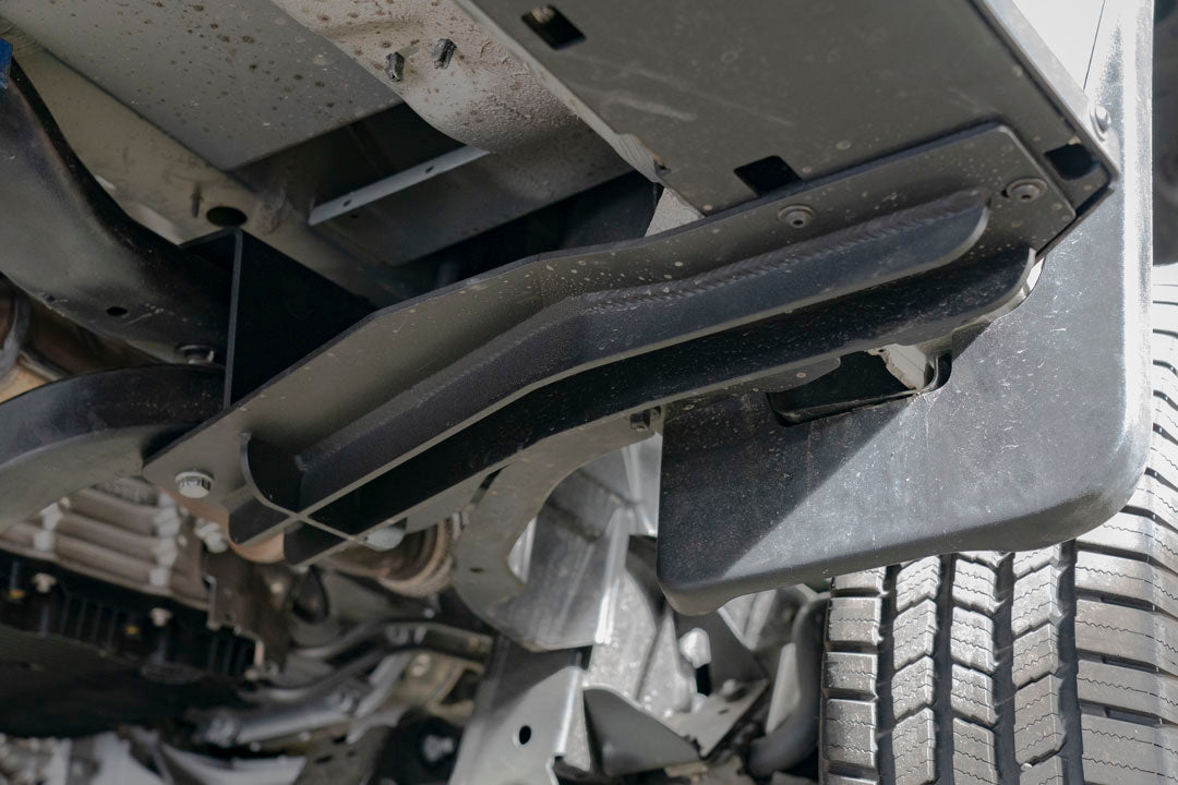 Rocker Guards - Sprinter AWD (2023+ 144 Wheelbase Only) by Van Compass: Close-up of metal bracket with bolts and screws, showcasing sturdy construction for van chassis reinforcement.