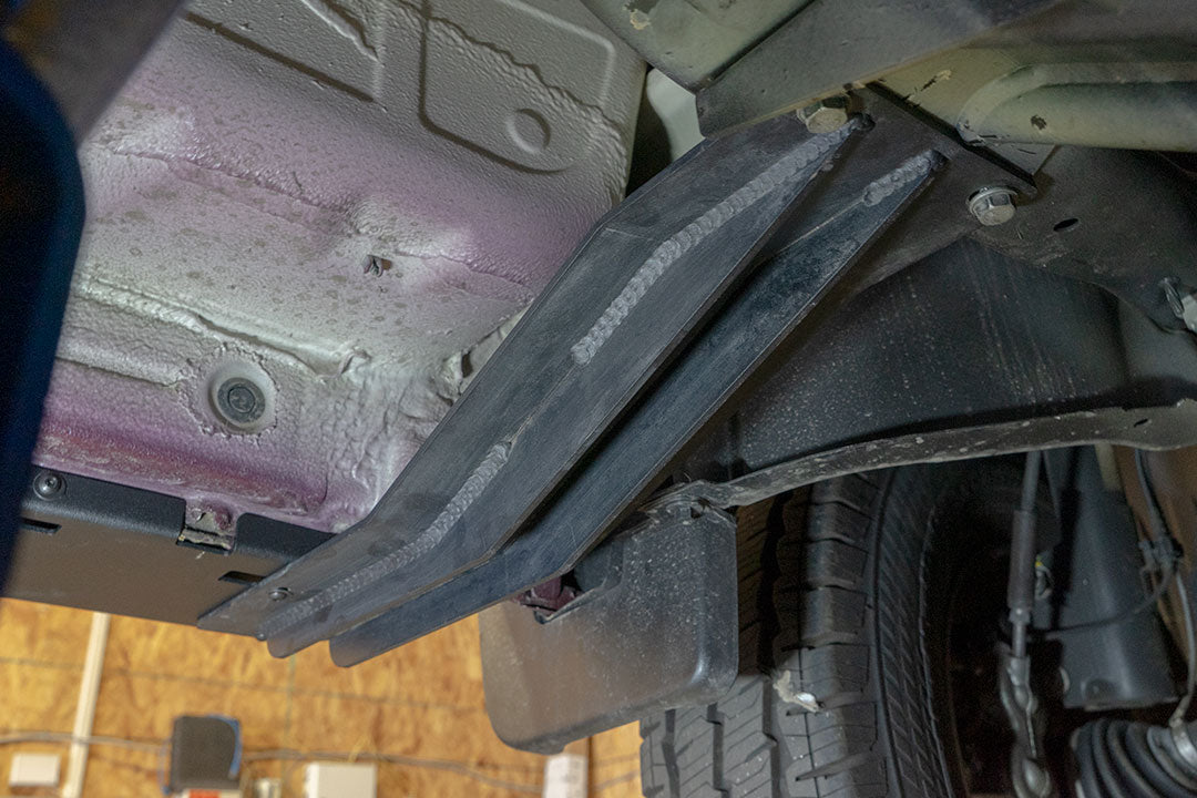 Close-up of Van Compass Rocker Guards for a 144 wheelbase Sprinter 4x4, showing robust metal construction and integrated step surfaces for vehicle protection and ease of access.