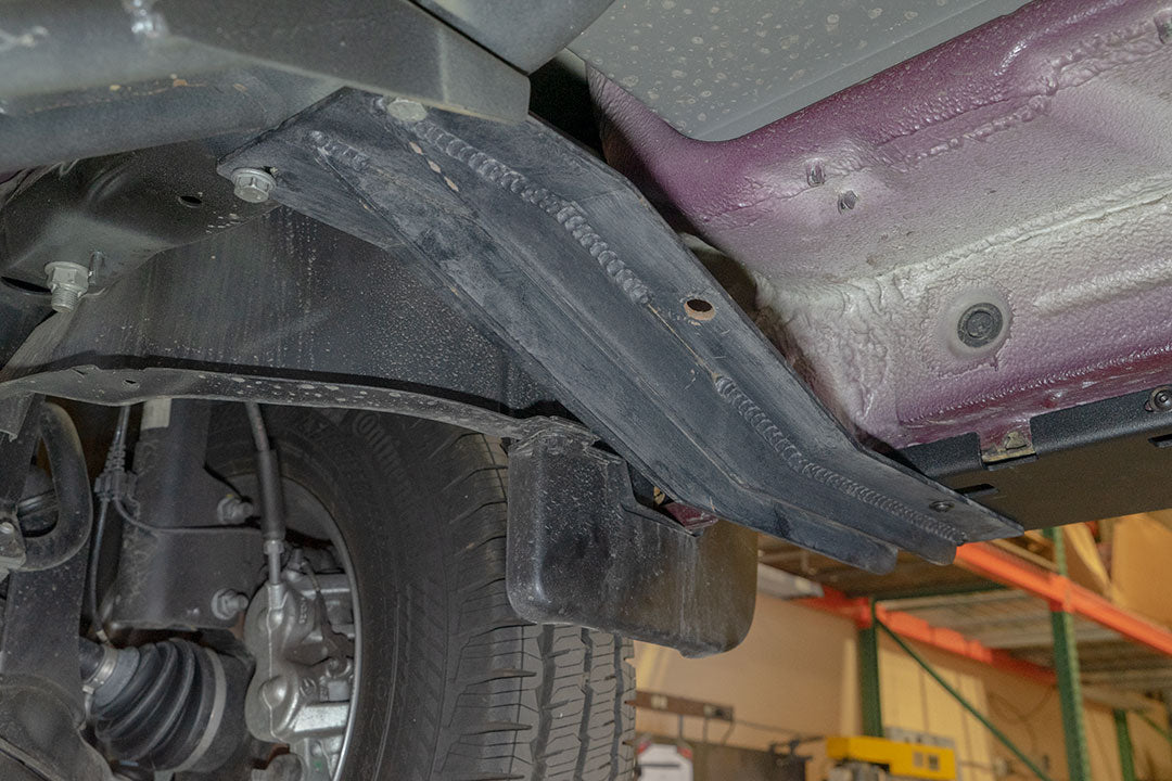 Close-up of Van Compass Rocker Guards installed on a 144 wheelbase Sprinter 4x4, showcasing robust metal frame and integrated step surface.