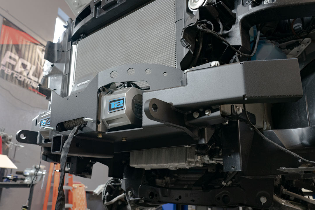 Close-up of the FRONT WINCH MOUNT WITH BULL BAR - SPRINTER (2019+) by VAN COMPASS, showing the reinforced metal structure and tow points behind the bumper.