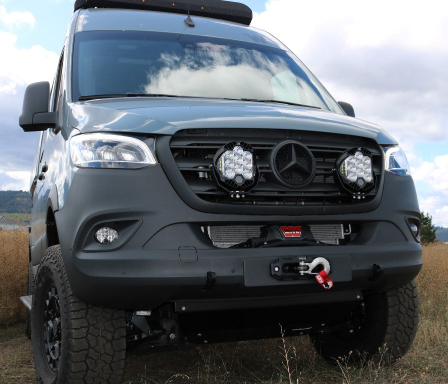 FLOATING LIGHT MOUNT - SPRINTER (2019-PRESENT) by VAN COMPASS, showing a black van with front lights mounted, enhancing aggressive styling and functionality.
