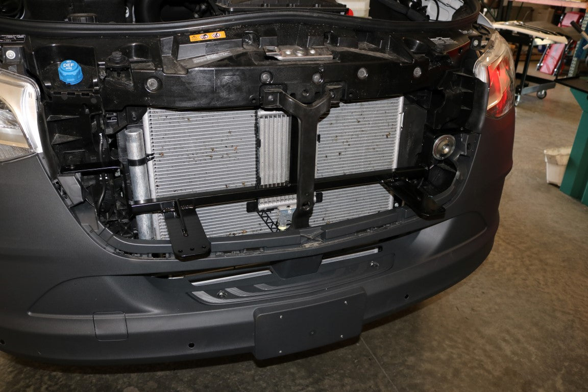 Floating Light Mount for Sprinter (2019-present) by Van Compass, installed behind the grill, showcasing auxiliary lights appearing to float in front of the vehicle’s radiator.