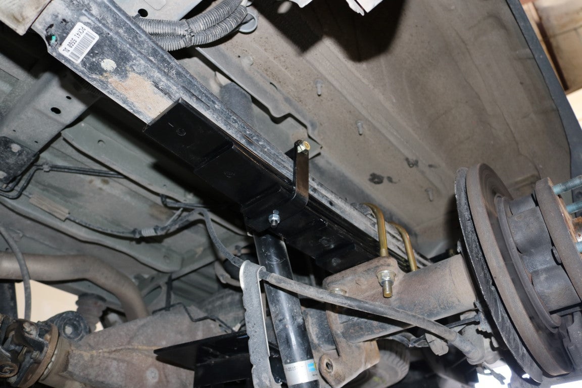 REAR 5 LEAF MINI SPRING PACK - TRANSIT (2015+ SINGLE REAR WHEEL) by VAN COMPASS, showing a metal frame with black brackets, enhancing vehicle stability and ride comfort.