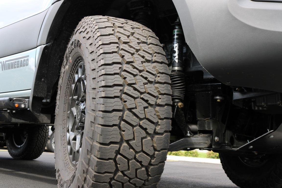 Close-up of a tire fitted with the Big Tire Mudflap Relocation Kit for 2019+ Mercedes Sprinter by Van Compass.
