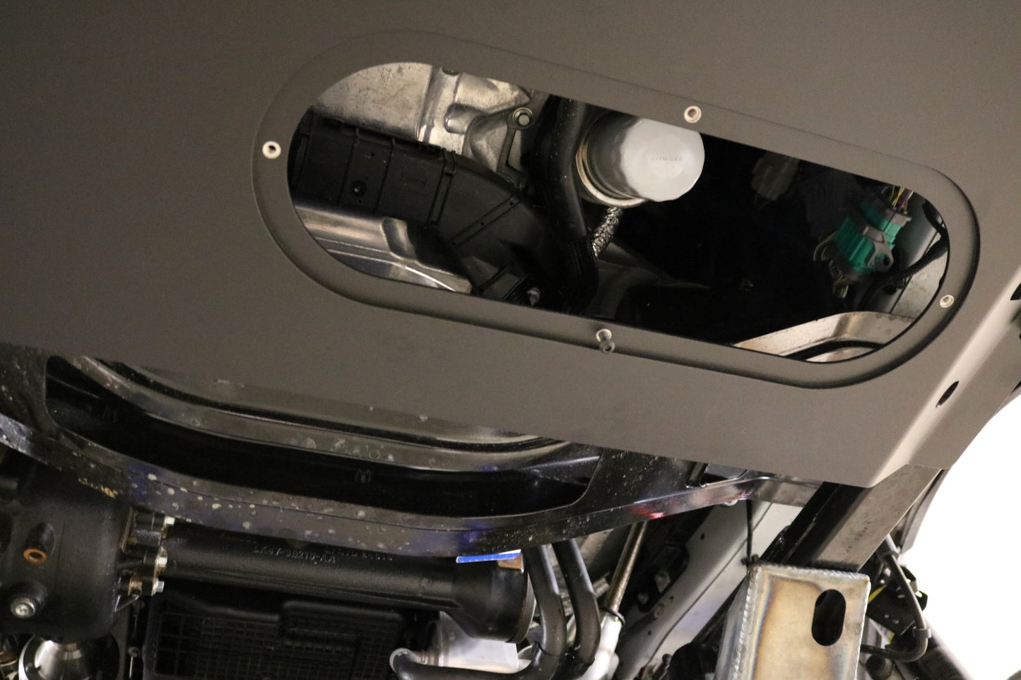 ALUMINUM INTERCOOLER SKID PLATE - TRANSIT (2015+) by VAN COMPASS, close-up showing access to engine oil filter.