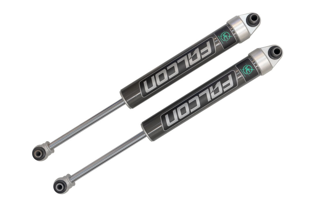 Stage 1 Topo 2.0 System - Transit RWD by Van Compass: a pair of black and silver Falcon 2.1 Monotube Shocks for improved ride quality and stability.