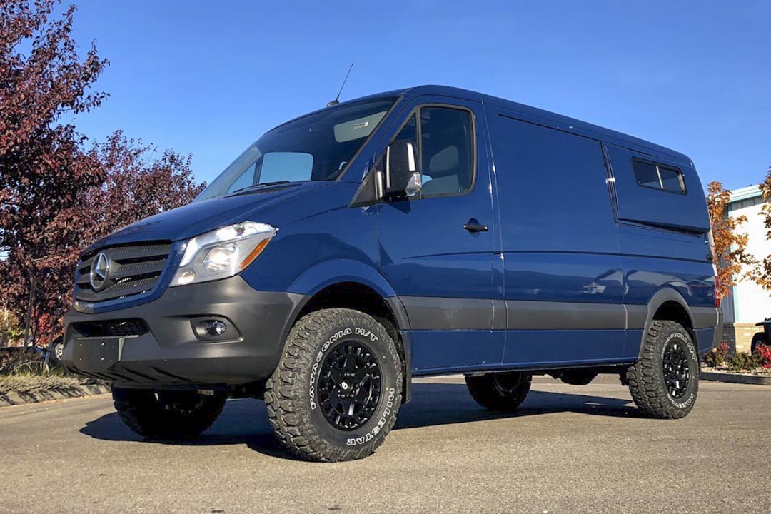 Blue van with larger tires and increased ground clearance, showcasing the Stage 4 System, 2 Lift - Sprinter 2WD (2007-2018 2500) by Van Compass.