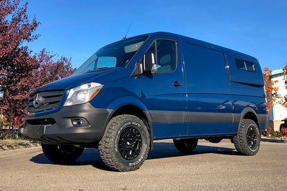 Blue van with larger tires and increased ground clearance, showcasing the Stage 4 System, 2 Lift - Sprinter 2WD (2007-2018 2500) by Van Compass.