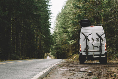 STRIKER 2 Lift Kit (Rear Only) - Sprinter 2WD (2019+) by VAN COMPASS installed on a van with bicycles mounted on the back, parked roadside.